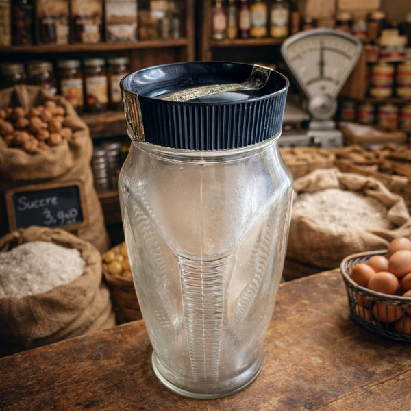 Bocal ancien d’épicerie L. Breton – Verre moulé trois faces avec couvercle noir