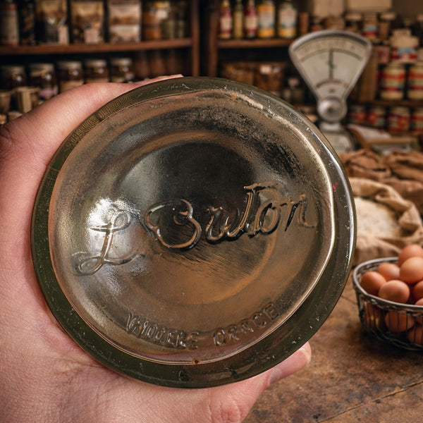 Bocal ancien d’épicerie L. Breton – Verre moulé trois faces avec couvercle noir