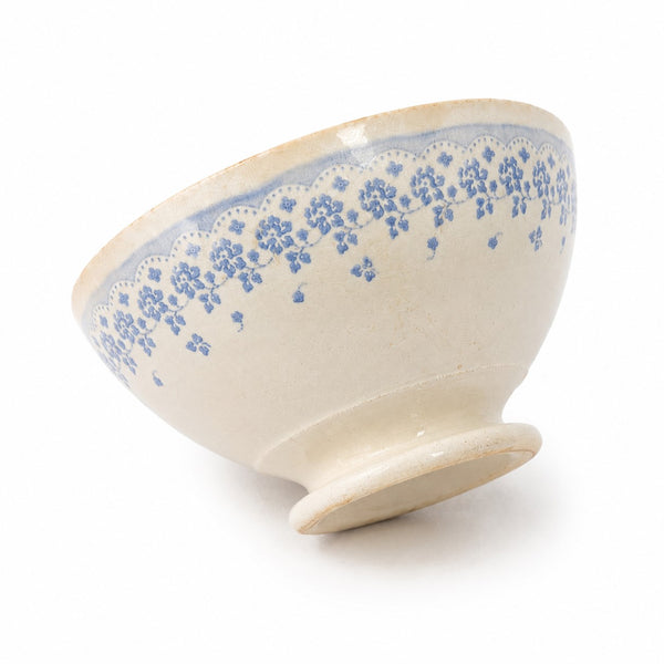 Bol ancien en faïence blanc cassé à décor floral bleu