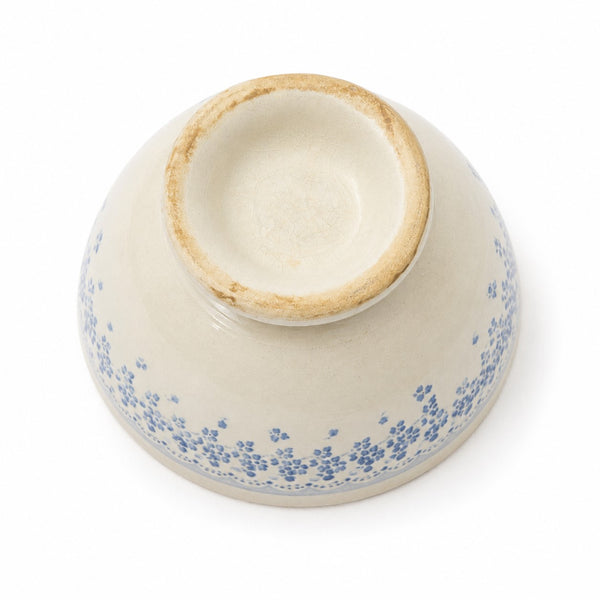 Bol ancien en faïence blanc cassé à décor floral bleu