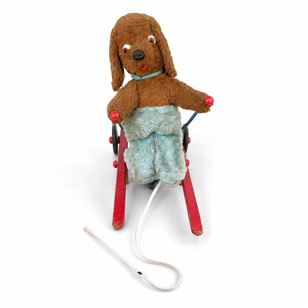 Jouet ancien à tirer animé – chien en peluche sur tricycle à skis