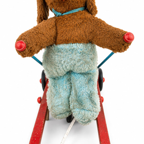 Jouet ancien à tirer animé – chien en peluche sur tricycle à skis