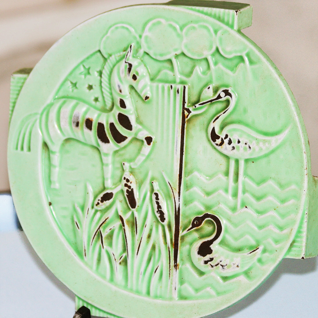 ancien dessous de plat en fonte émaillée art déco décor d'animaux stylisés ancien dessous de plat en fonte émaillée art déco décor d'animaux stylisés
